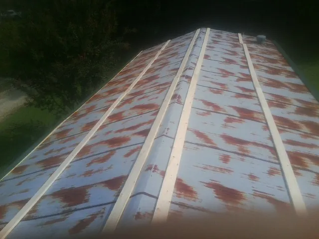Rusted metal roof panels with new wood purlins before replacement — Storm Damage Roof Repair in Paden City by Roofing Brothers