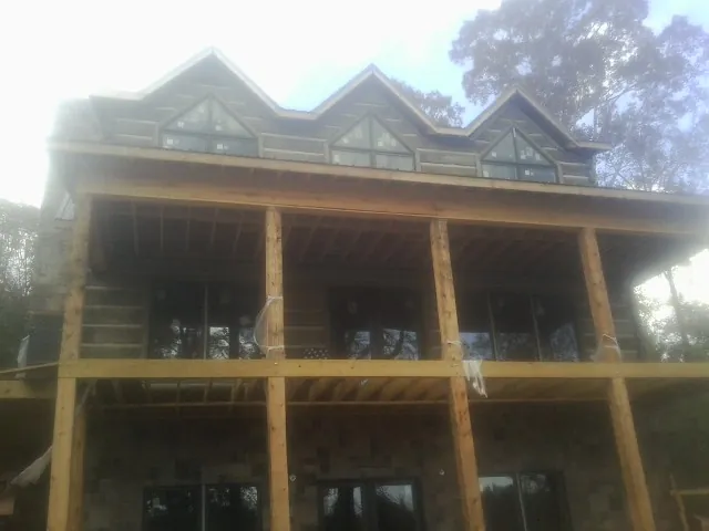 Dormers and porch framing on a large log home under construction — Roof Coating work by our crew in Paden City