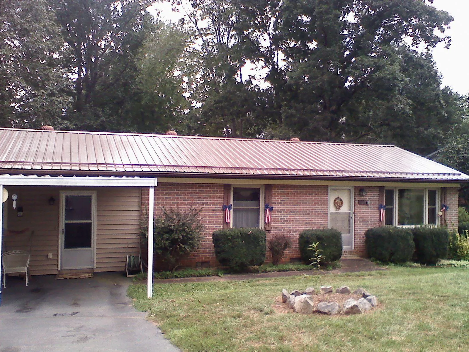 Bronze metal roof and carport on a brick ranch home — Roof Repair work by our crew in Paden City